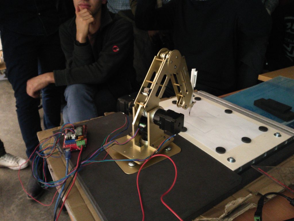 Halb aufgebauter Dobot-Roboter mit Arbeitsfläche und Stift in der Hand